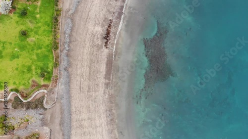Aerial view of ocean shore, sandy beach of Costa Adeje city, Tenerife. Beautiful clear turquoise calm water on coastline, coastal tide, sand ripples. 4K drone video, dynamic birds-eye rising shot