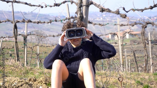 Obraz na płótnie 10 year old boy with 3d AI virtual reality headset viewer in nature immerses himself in an immersive visual experience with reality augmented by artificial intelligence w salonie
