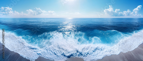 Wide Panoramic Shot of an Endless Coastline with Rolling Waves and Bright Blue Sky photo