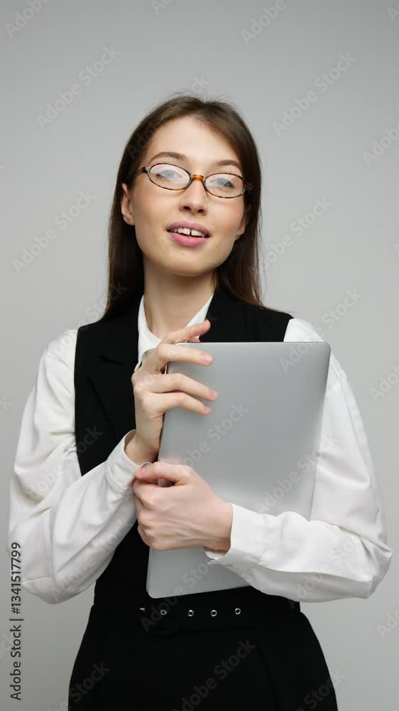 Confident woman dressed in formal attire holds a tablet while smiling warmly at the camera. Confident woman dressed in formal attire holds a tablet while smiling warmly at the camera.