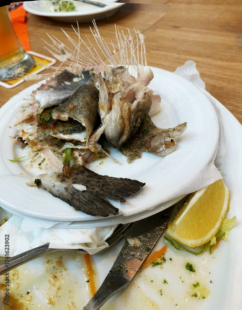 Fish bones lying on a plate after the meal