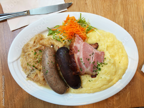 Obraz na płótnie A typical German specialty: a meat platter, schlachtplatte, with liver sausage, crackling, sauerkraut, belly and mashed potatoes. w salonie