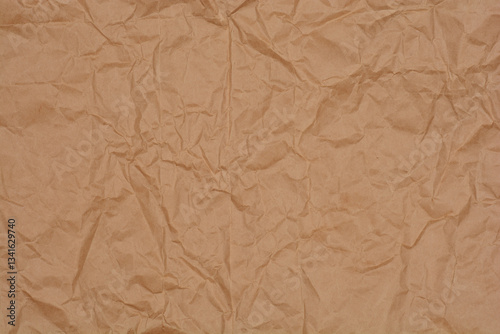 A close-up shot of crumpled kraft paper, showcasing its texture and neutral brown color