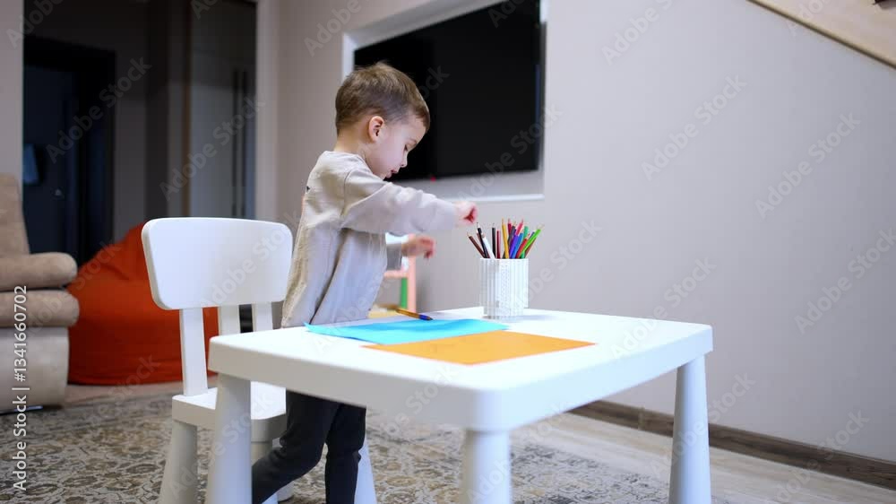 Child enjoys drawing activity. A young child focuses on drawing at a small table in a cozy indoor space during daylight hours. Child enjoys drawing activity. A young child focuses on drawing at a small table in a cozy indoor space during daylight hours.