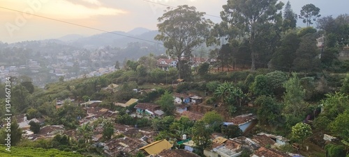 captures a scenic hillside settlement, likely in a hill station or mountainous region. The foreground features a small village with traditional houses