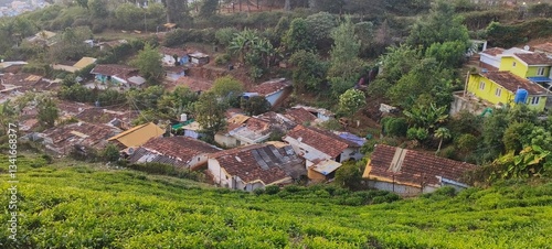 captures a scenic hillside settlement, likely in a hill station or mountainous region. The foreground features a small village with traditional houses