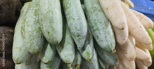 fresh vegetables, specifically a stack of ash gourds