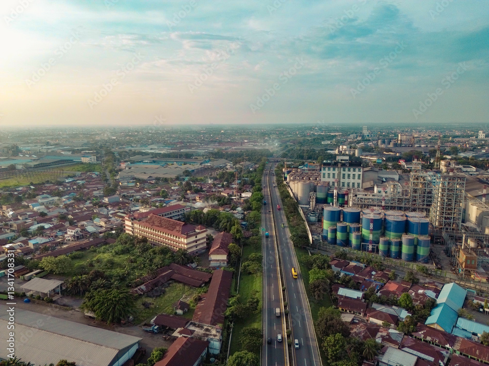 Obraz premium Aerial view of Medan Industrial Park, Indonesia, showcasing factories, highways, and urban development. Perfect for themes of industry, logistics, infrastructure, and economic growth
