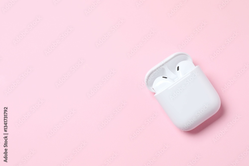 Wireless ear phones with a white box on color background Wireless ear phones with a white box on color background