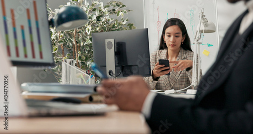 Office workers sit at their desks in front of computer monitors, not attending to their duties, using their phones browsing social media scrolling through pages chatting with friends break from work