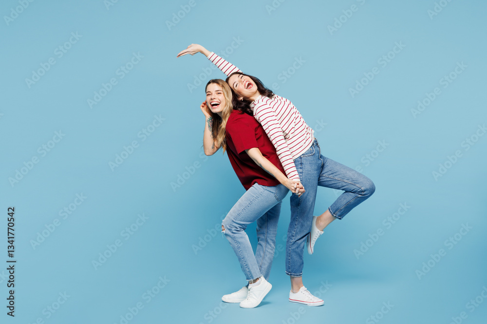 Full body young couple two friends women wearing red casual clothes together stand back to back lean aside dance have fun isolated on pastel plain light blue cyan background studio. Lifestyle concept. Full body young couple two friends women wearing red casual clothes together stand back to back lean aside dance have fun isolated on pastel plain light blue cyan background studio. Lifestyle concept.
