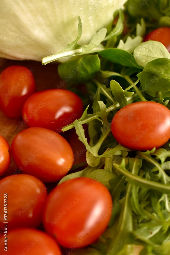 Fresh ripe cherry tomatoes and lettuce on a cutting board Fresh ripe cherry tomatoes and lettuce on a cutting board