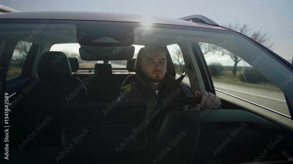 Hood view through the windshield of a man driving, checking mirrors, and touching the car touchscreen Hood view through the windshield of a man driving, checking mirrors, and touching the car touchscreen
