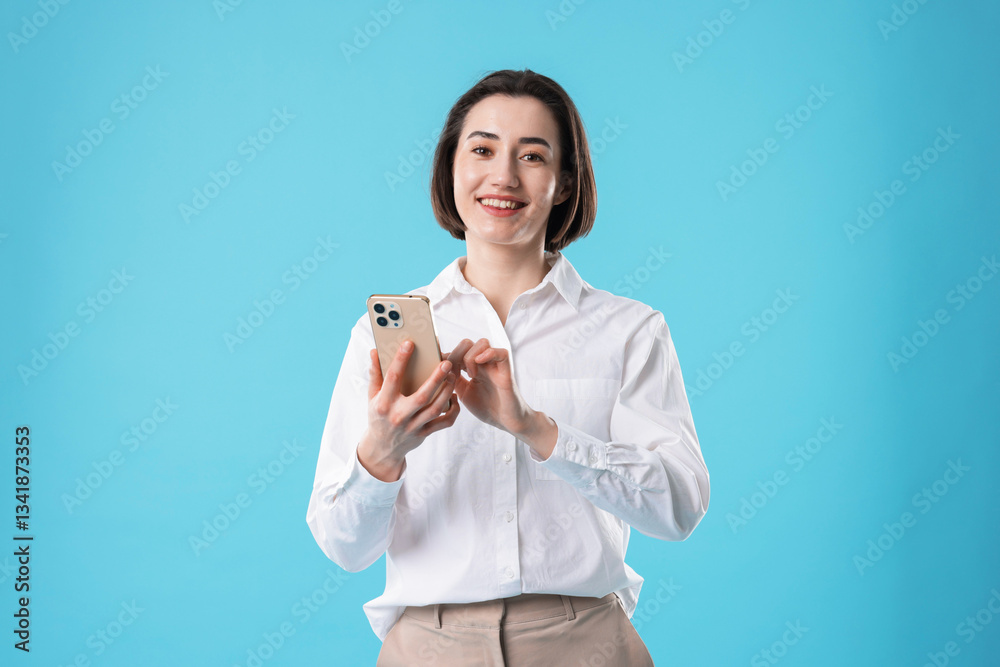 Smiling secretary using smartphone on light blue background Smiling secretary using smartphone on light blue background