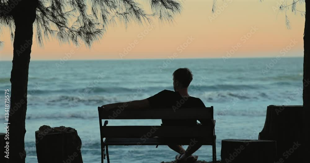 Man relaxing on bench by ocean, silhouette, sunset, tranquil scene, peace, solitude, nature Man relaxing on bench by ocean, silhouette, sunset, tranquil scene, peace, solitude, nature