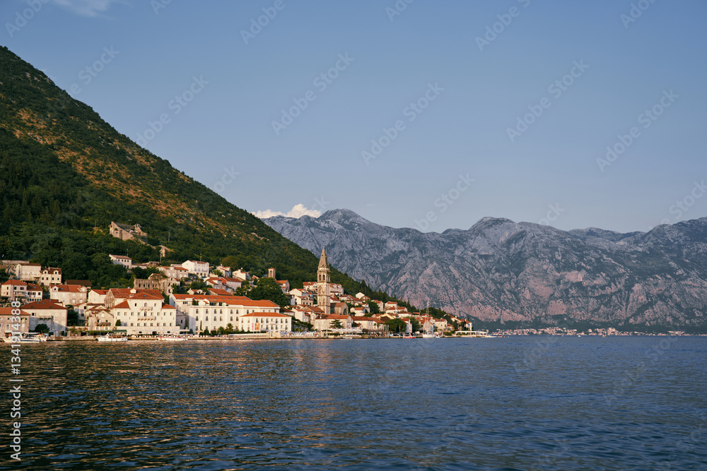 Bell tower of the church of St. Nicholas in Perast among old houses with red roofs. Montenegro Bell tower of the church of St. Nicholas in Perast among old houses with red roofs. Montenegro