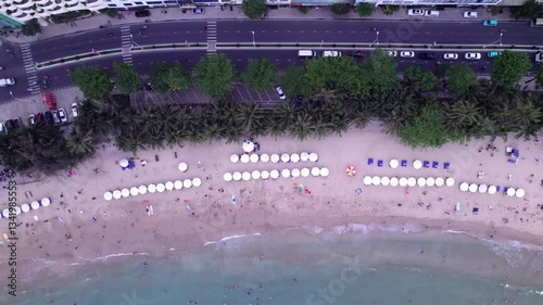 Big beach with people in Nha Trang, Vietnam. Aerial view on public beach in Asian city on on the shore ocean.