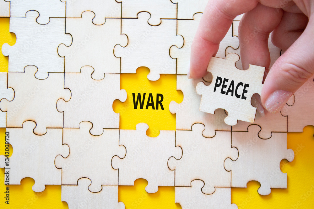 Fototapeta premium War or Peace symbol. Concept word War or Peace on wooden puzzle. Businessman hand. Beautiful yellow background. Business and War or Peace concept. Copy space
