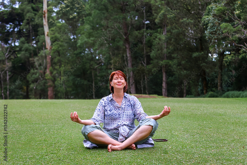Fototapeta premium Woman meditating peacefully in a green park, embracing nature's serenity.