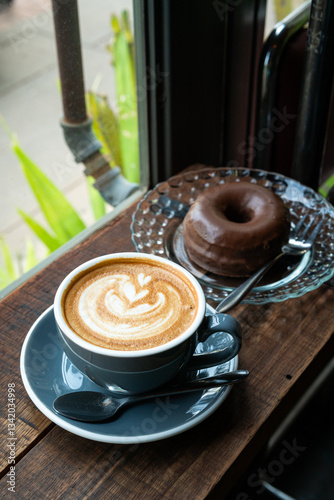 Obraz na płótnie Hot coffee latte with latte art milk foam in cup mug and Homemade chocolate Donut on wood desk on top view. As breakfast In a coffee shop at the cafe,during business work concept,vintage style w salonie