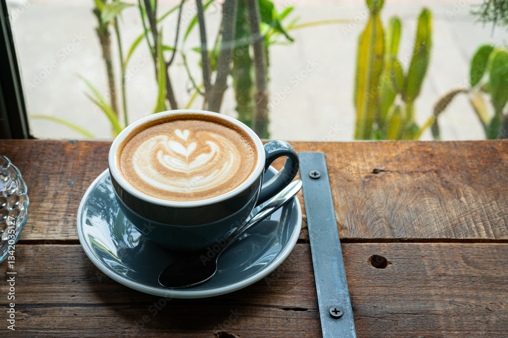 Hot coffee latte with latte art milk foam in cup mug on wood desk on top view. As breakfast In a coffee shop at the cafe,during business work concept,vintage style