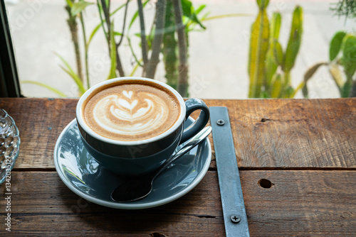 Obraz na płótnie Hot coffee latte with latte art milk foam in cup mug on wood desk on top view. As breakfast In a coffee shop at the cafe,during business work concept,vintage style w salonie