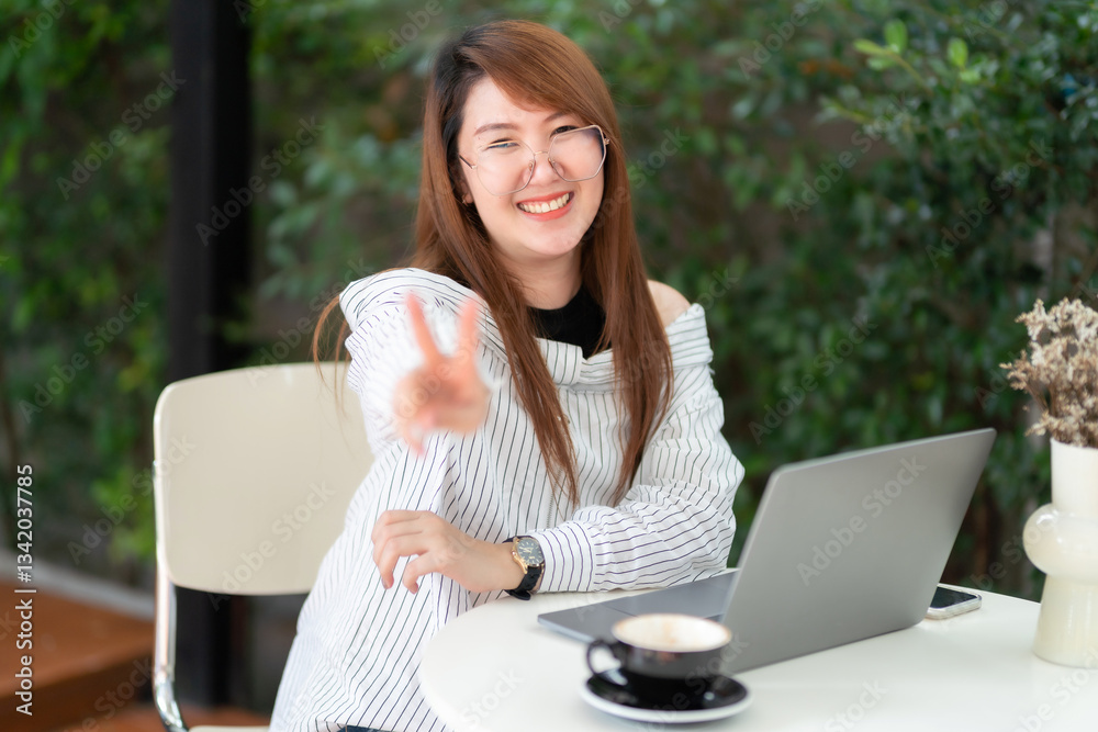 asian freelance people business female two fingers up fighting with talking making using casual working with laptop computer for browsing internet, blogging and smartphone,notebook in coffee shop.