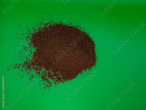 Scattered ground coffee, on a green background, top view