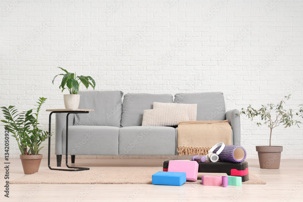 Naklejka premium Sports equipment with headphones on carpet in living room interior