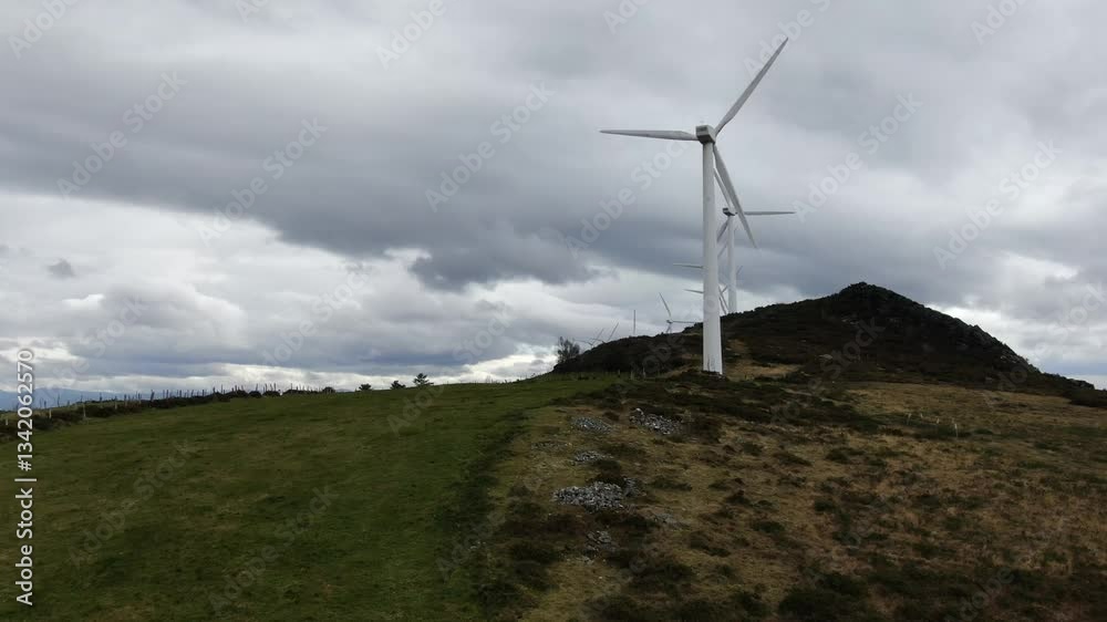 Wind turbines on a hill under dramatic cloudy sky