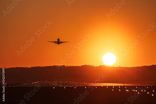 Obraz na płótnie Airplane landing with a golden light of sunset in Cracow Balice Airport during a februray day. w salonie