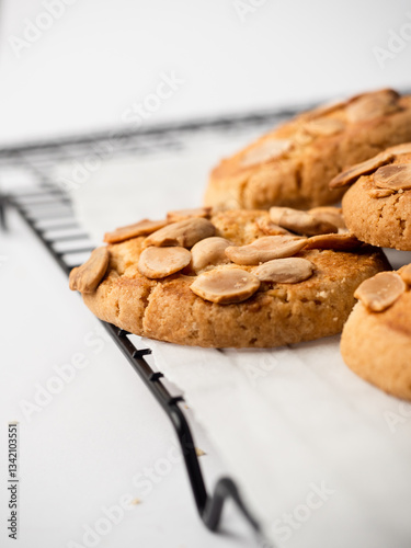 Bunch of almond cookies on a cooling tray with a white background