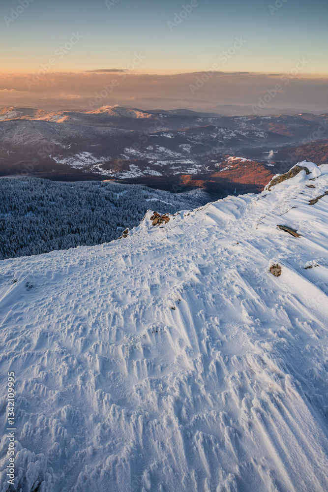 Babia Góra at sunset, covered in winter snow. A stunning mountain landscape in Babia Góra National Park, Poland. Golden light contrasts with icy peaks, creating a breathtaking view for nature and trav