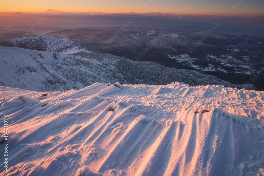 Babia Góra at sunset, covered in winter snow. A stunning mountain landscape in Babia Góra National Park, Poland. Golden light contrasts with icy peaks, creating a breathtaking view for nature and trav