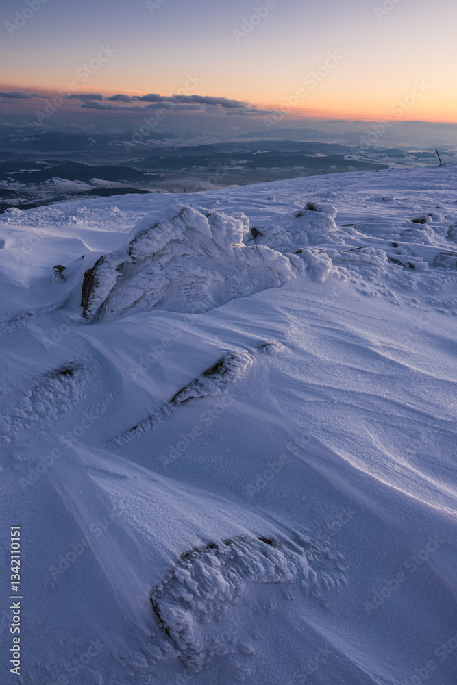 Babia Góra at sunset, covered in winter snow. A stunning mountain landscape in Babia Góra National Park, Poland. Golden light contrasts with icy peaks, creating a breathtaking view for nature and trav