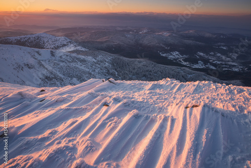 Babia Góra at sunset, covered in winter snow. A stunning mountain landscape in Babia Góra National Park, Poland. Golden light contrasts with icy peaks, creating a breathtaking view for nature and trav