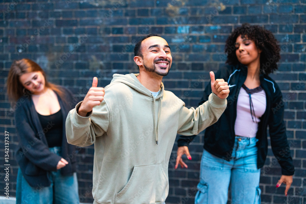 Happy dancers showing thumbs up in front of brick wall