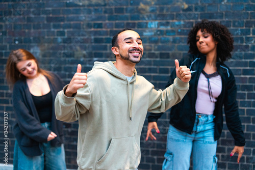 Happy dancers showing thumbs up in front of brick wall