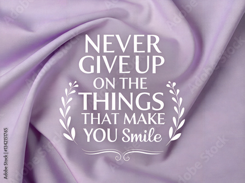 Motivational quote on lilac fabric backdrop. Never give up on the things that make you smile. Elegant, soft texture. Inspirational message.
