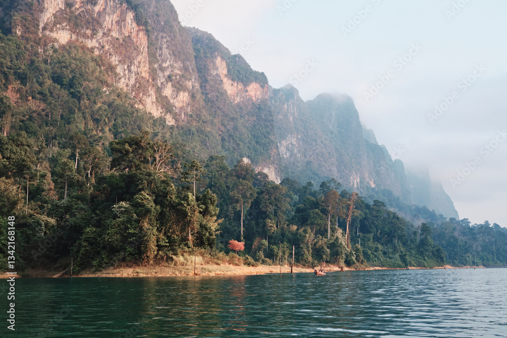 Exploration of lush green mountains and tranquil waters at dawn in a remote natural reserve Exploration of lush green mountains and tranquil waters at dawn in a remote natural reserve