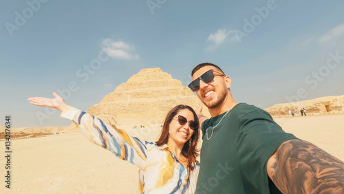 Tourists taking selfie with saqqara step pyramid in background, egypt