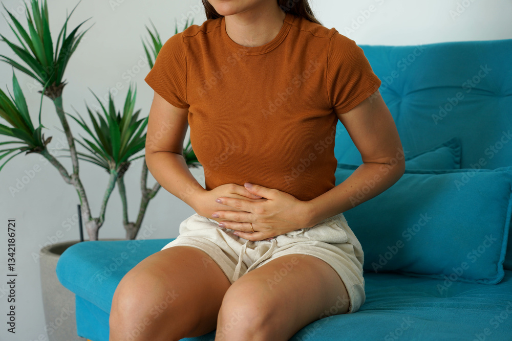 Irritable bowel syndrome. Young woman holds the lower part of the abdomen due to sudden pain.