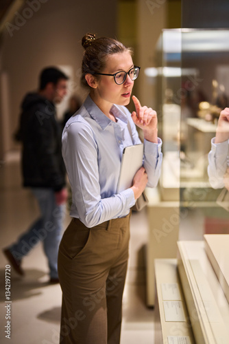 visitor in historical museum looking at art object