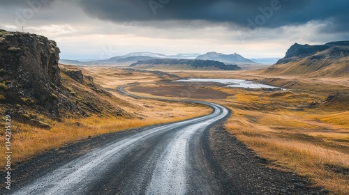 Dramatic Icelandic landscape with a winding road under a cloudy sky panorama
