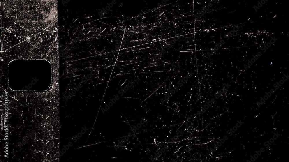 Old scratched film showing a rectangular hole on black background