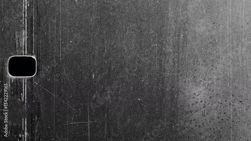 Old scratched film showing rectangular hole on black background