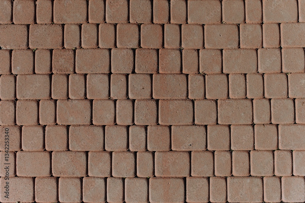 Naklejka premium A detailed view of interlocking pavement blocks showcasing a textured surface and earthy tones, suitable for landscaping or outdoor flooring projects.