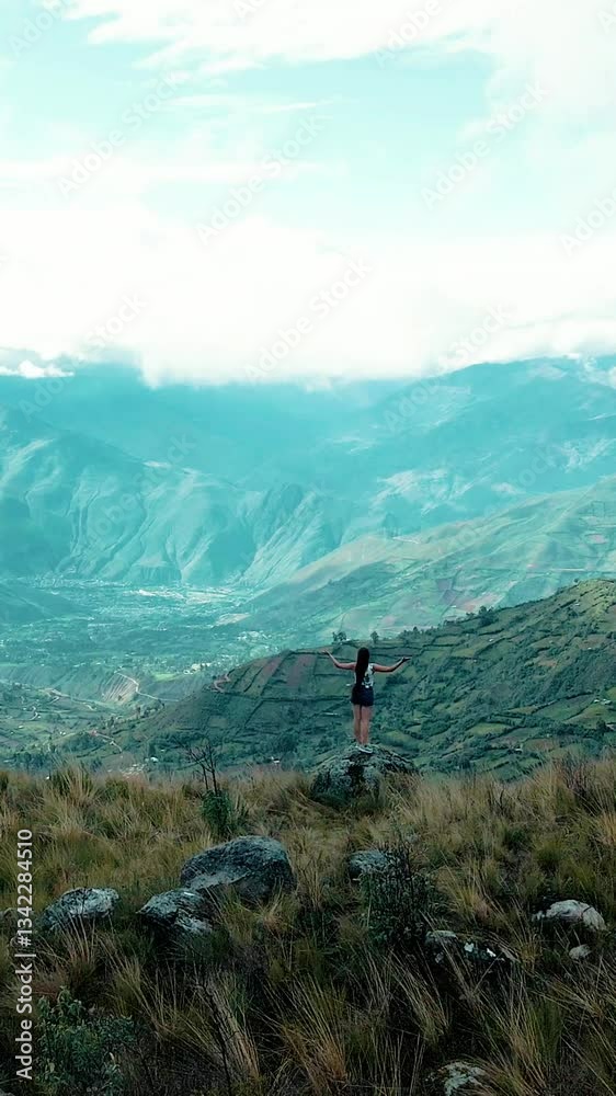 Joven corriendo en la naturaleza entre montañas y paisajes mágicos . Chica en shorts disfrutando el aire libre y el turismo en la montaña.estilo de vida saludable .video drone vertical