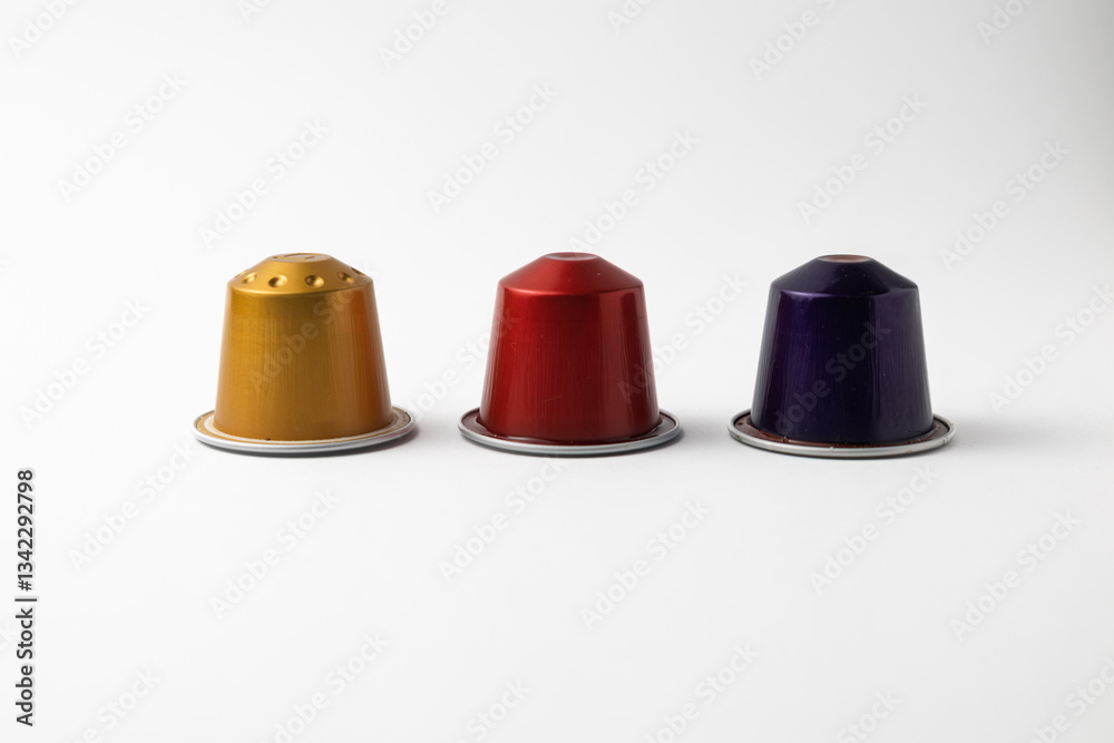 Colorful coffee capsules standing in a row on white background Colorful coffee capsules standing in a row on white background