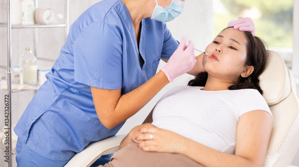 Obraz premium Skilled cosmetologist performing procedure for injecting beauty injections for the patient